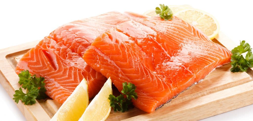 Fresh raw salmon fillet on cutting board on white background