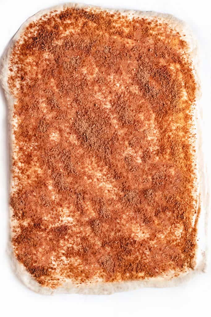 cinnamon and sugar sprinkled on rolled dough