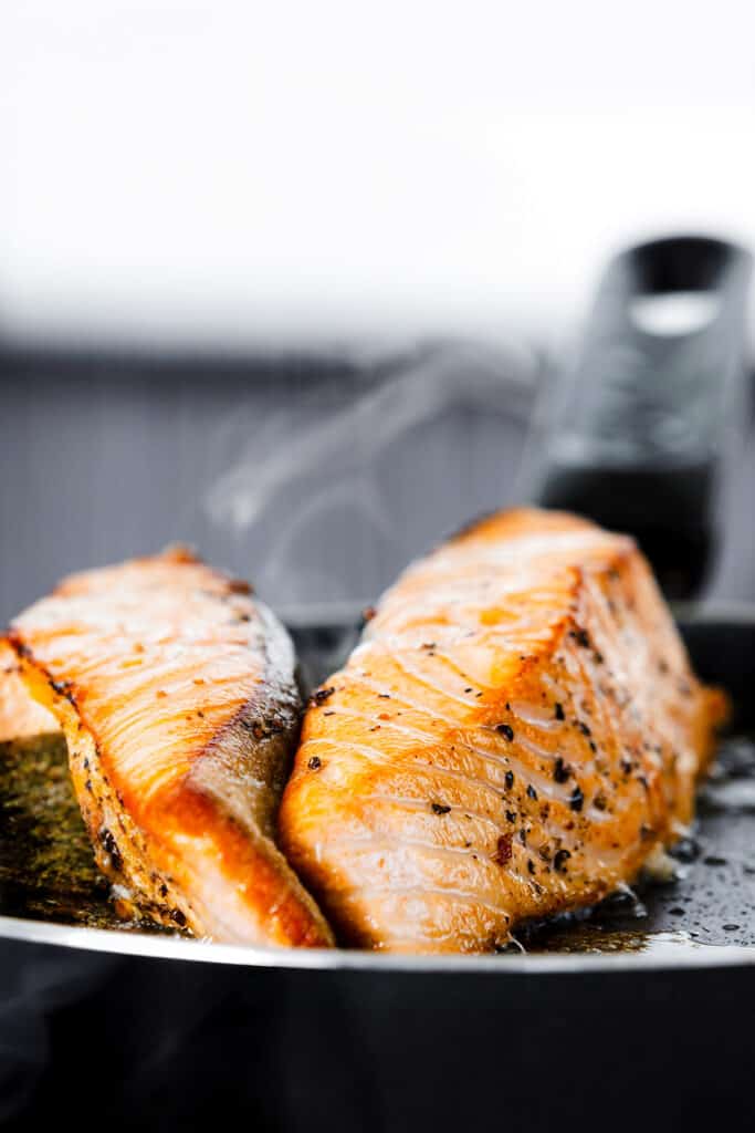 two salmon fillets on their sides in the pan.