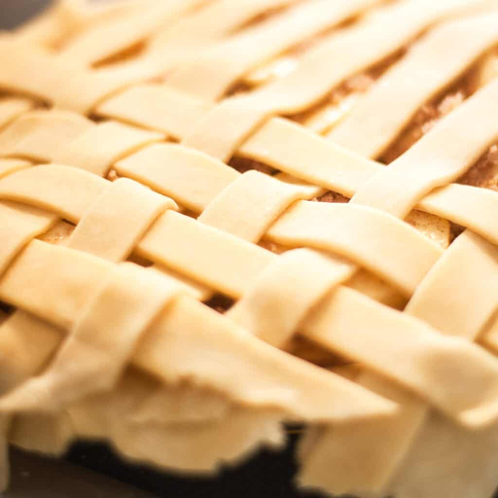 lattace dough over apple filling in a pie plate