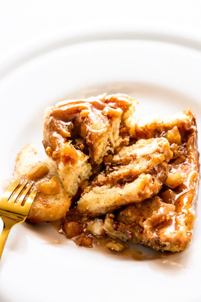a Cinnamon Rolls with Apple Pie Filling broken open on a plate to reveal the inside of the bun.