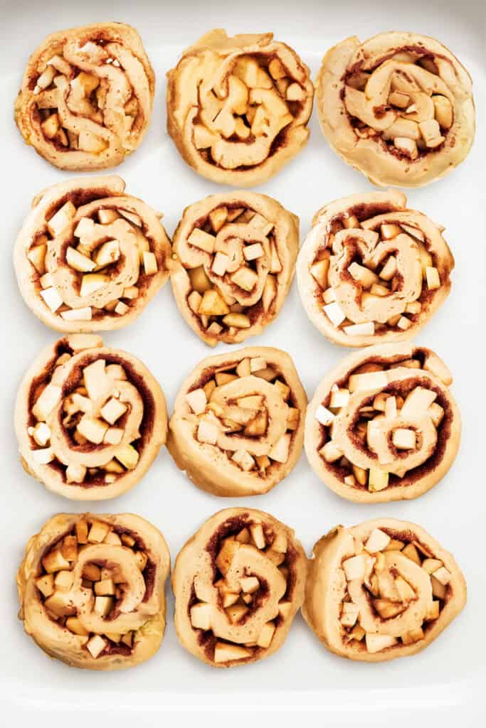 the sliced, raw Cinnamon Rolls With Apple Pie Filling in a greased pan.
