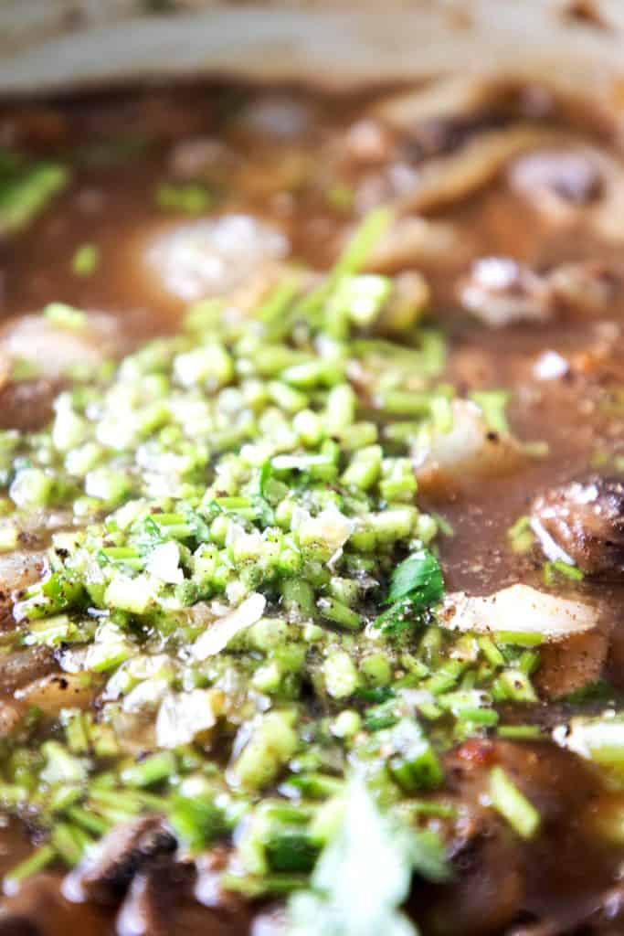 Chopped parsley stems added to the stew mixture in the pot