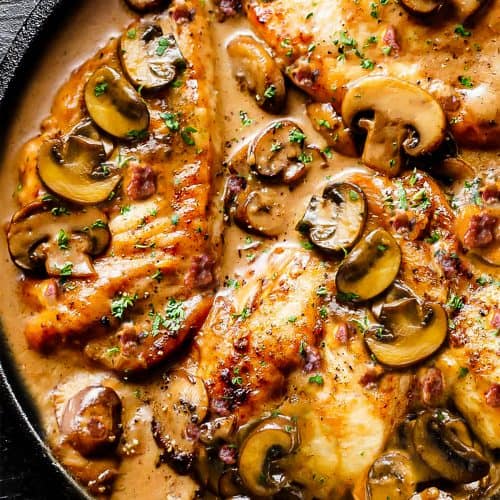 a pan of chicken cutlets in a mushroom sauce