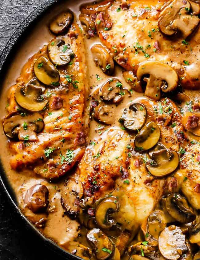 a pan of chicken cutlets in a mushroom sauce