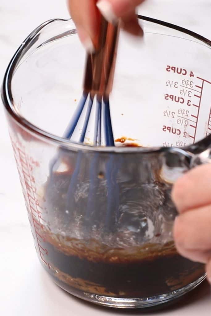 soy sauce and other ingredients being whisked