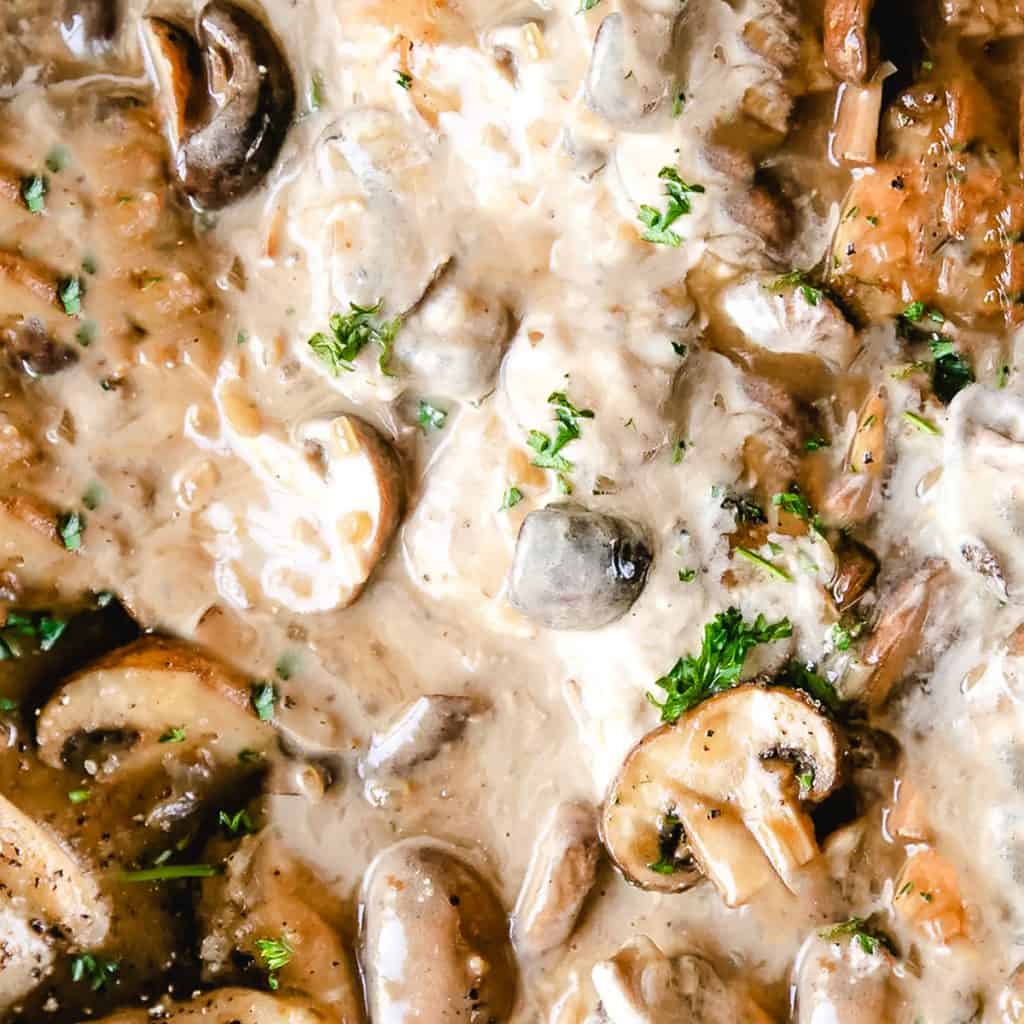 sour cream being poured into mushrooms and stock