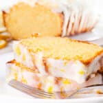 A sliced lemon pound cake with icing and lemon zest.