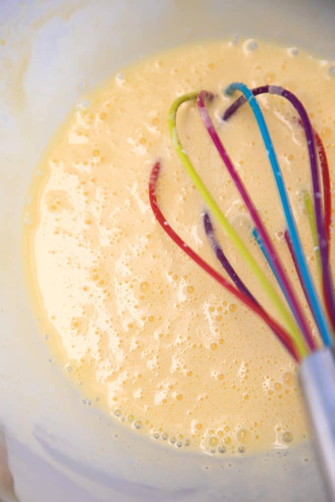 a whisk whisking eggs and cream