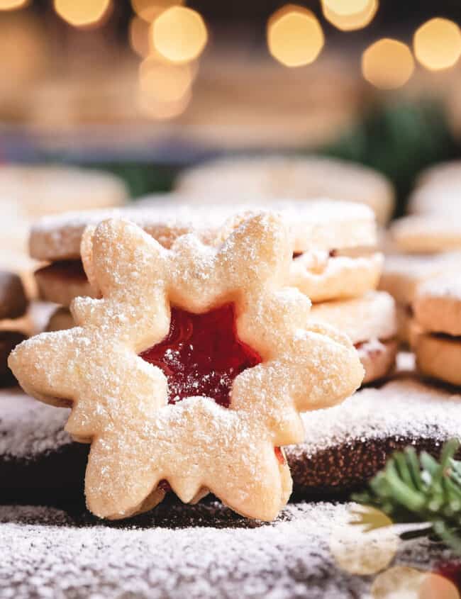 a snowflake shaped cookie filled with jam on a platter