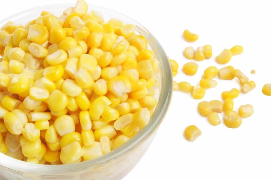 a blow of corn with some scattered on the table