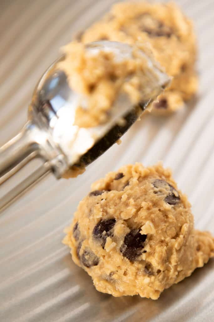 cookie dough being dropped onto a baking tray