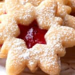 a snowflake xmas cookie filled with jam and dusted with powdered sugar