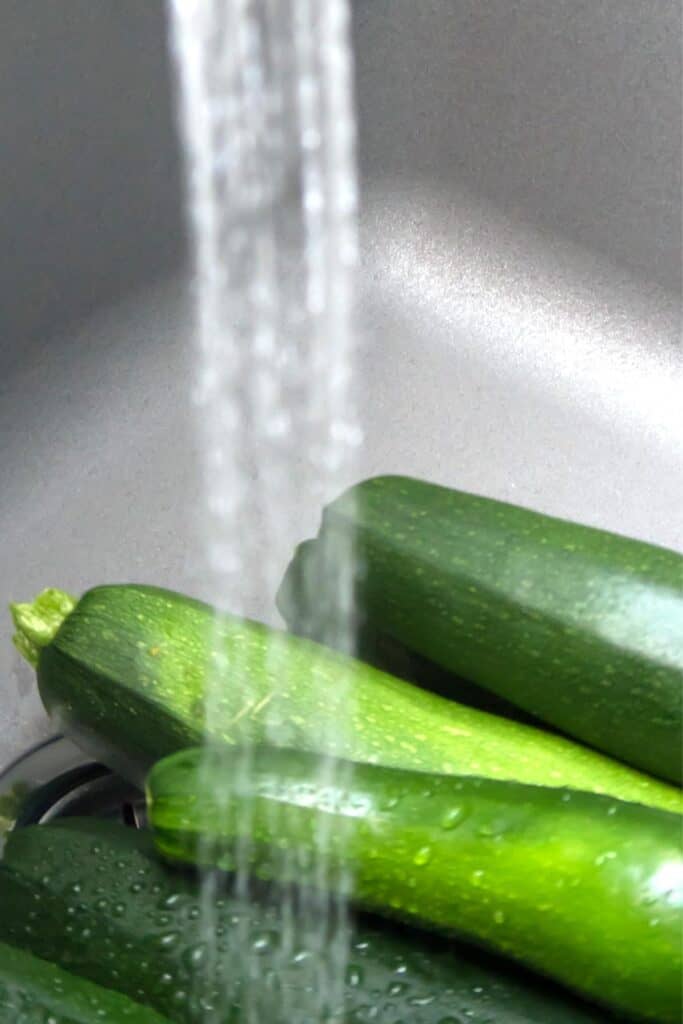 washing zucchini under cold water