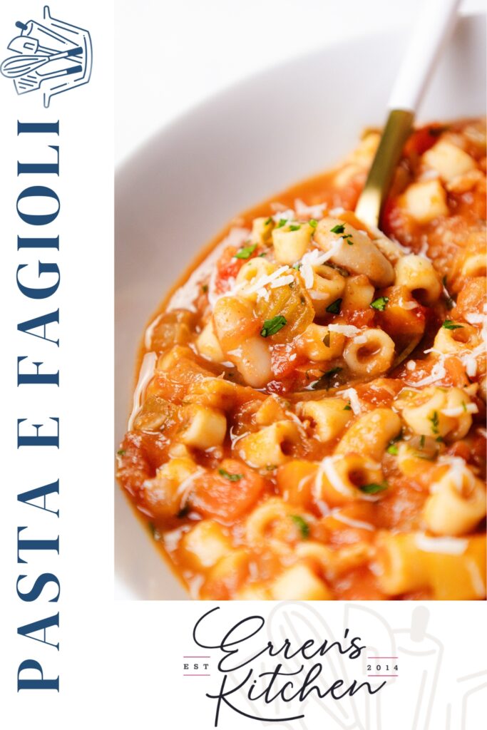 Close-up of Pasta E Fagioli Soup with small pasta, beans, tomato, and herbs, topped with grated cheese. A gold spoon rests in the bowl, while “Pasta e Fagioli” is written elegantly along the side.