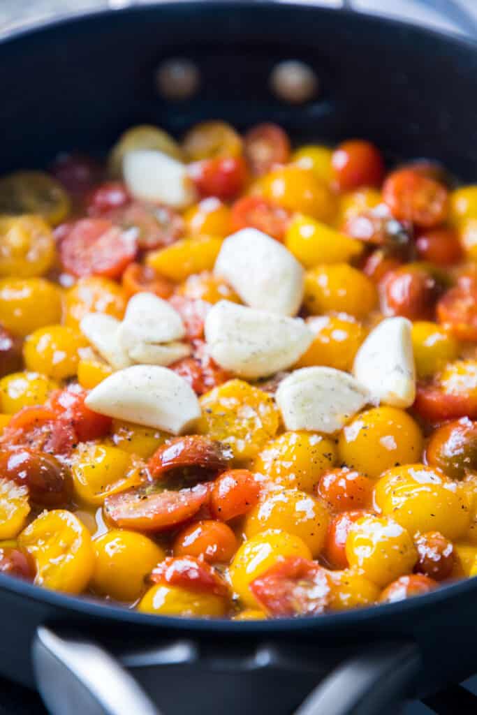 tomatoes and garlic cloves in a pan