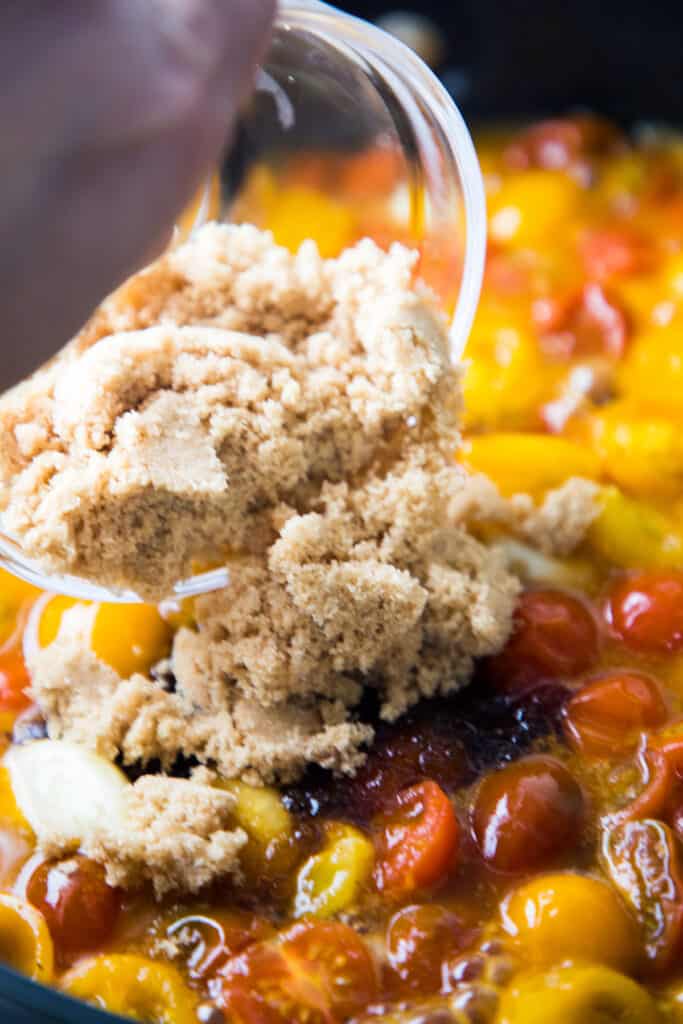 brown sugar added to tomatoes in a pan