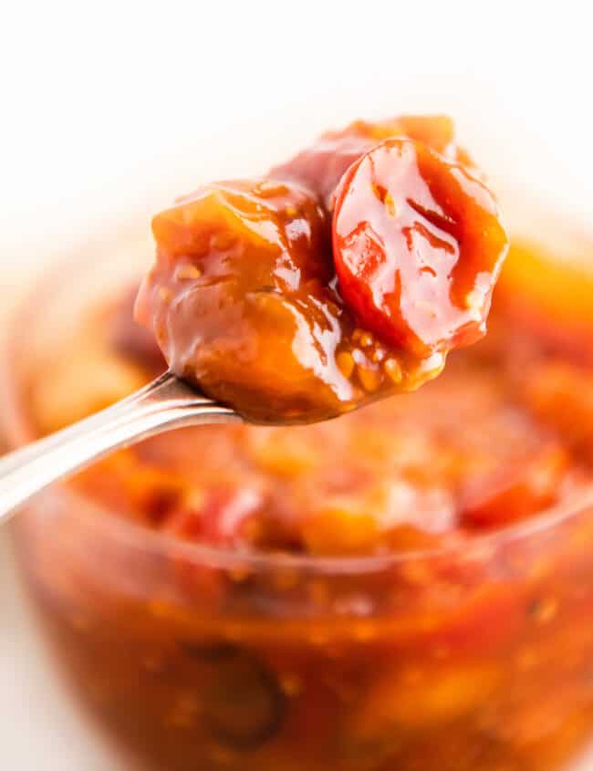 a jar of tomato jam with a spoonful
