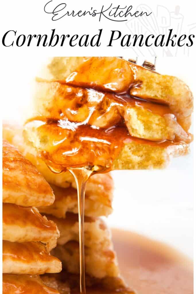 A close-up image of a forkful of cornbread pancakes with syrup being poured over them, highlighting the golden color and the syrupy sheen. The background features the text 'Erren's Kitchen Cornbread Pancakes' indicating the recipe or source of the dish.