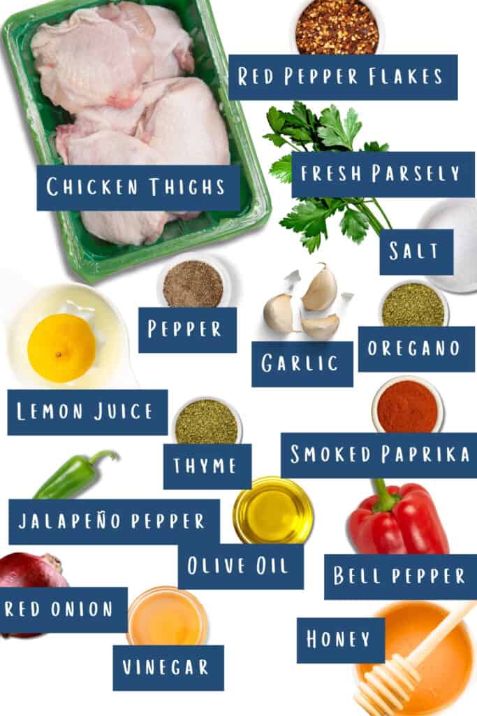 An assortment of ingredients for cooking arranged on a white background, including chicken thighs, red pepper flakes, fresh parsley, salt, pepper, garlic, lemon juice, thyme, smoked paprika, jalapeño pepper, olive oil, red onion, vinegar, bell pepper, and honey.