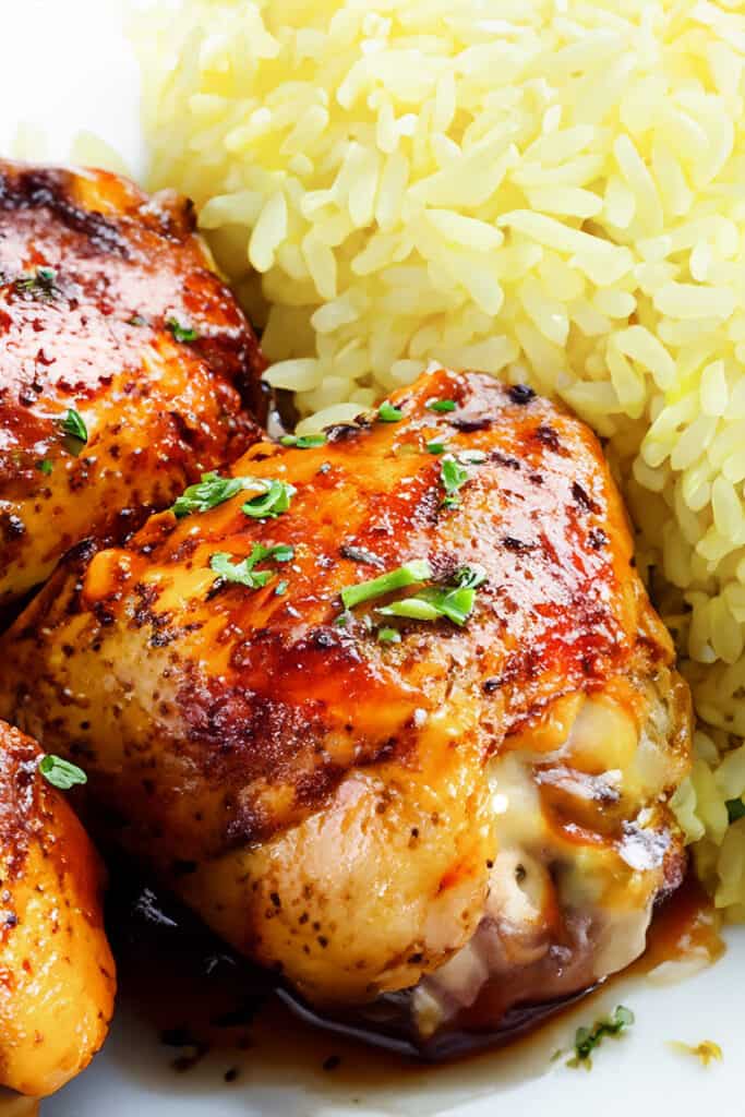 Peri Peri Chicken thighs on a plate with yellow rice.