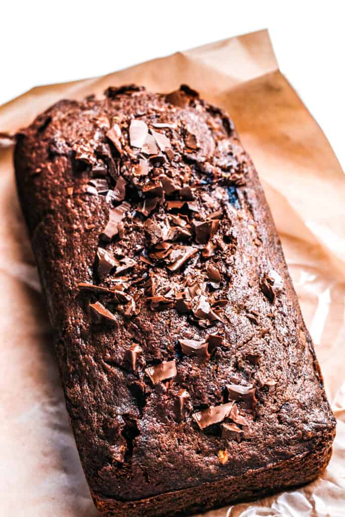 a freshly baked chocolate banana cake on a piece of baking paper.
