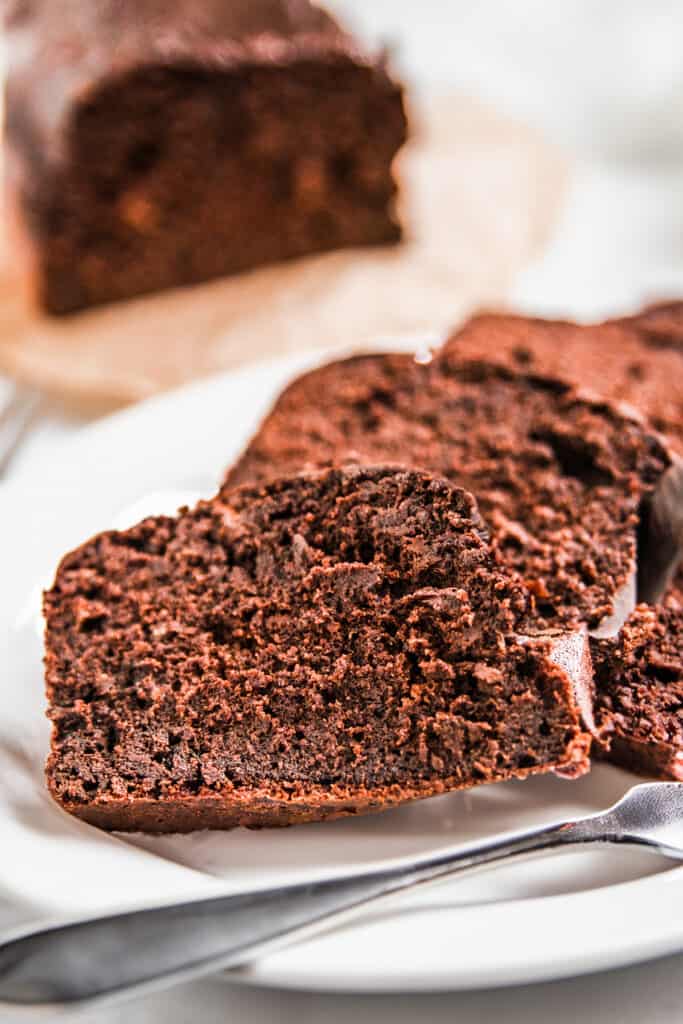 slices of chocolate banana cake on a plate with a fork.