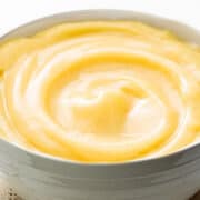 a white bowl filled with pastry cream that's swirled on top