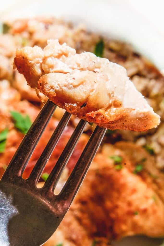 a forkful of chicken over a plate of rice