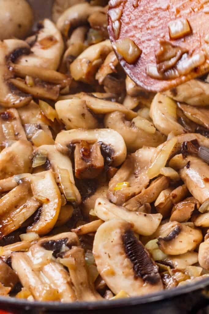 onions and mushrooms cooking in a pan