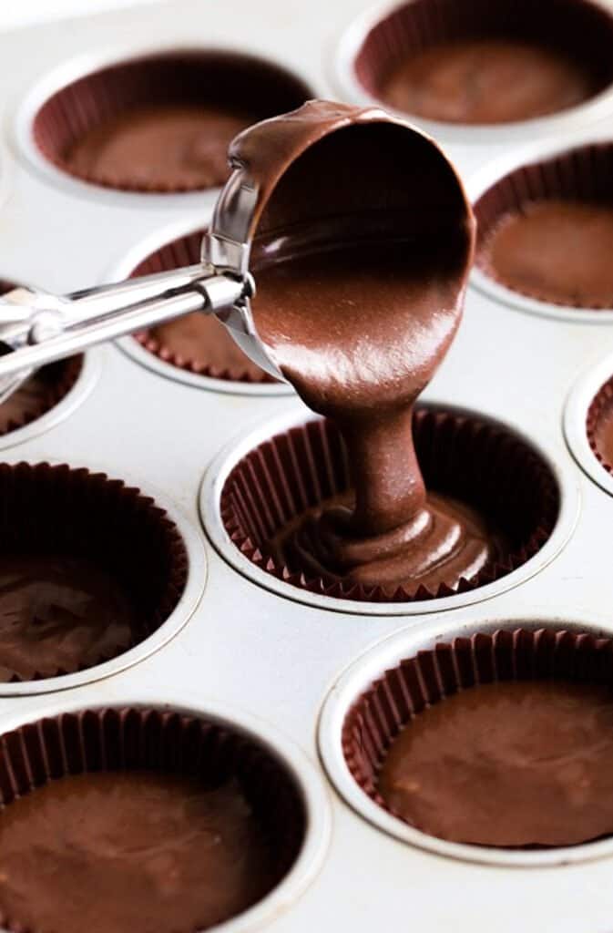 chocolate cake batter poured into a muffin tin