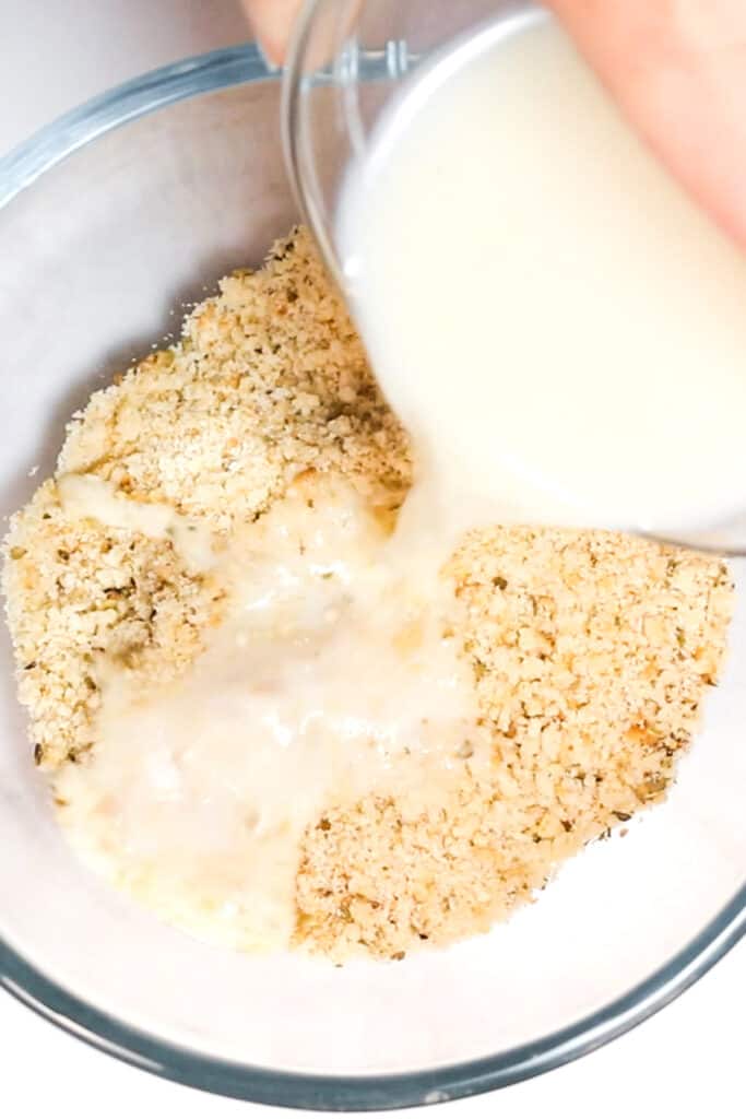 milk being poured into bread crumbs