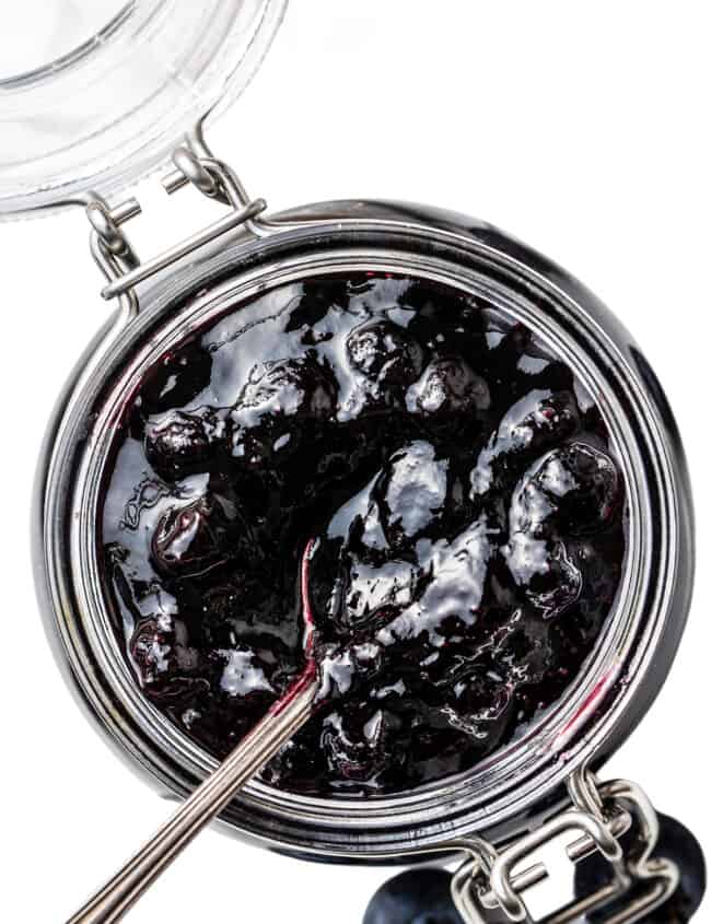 A close up image of a jar of blueberry jam.