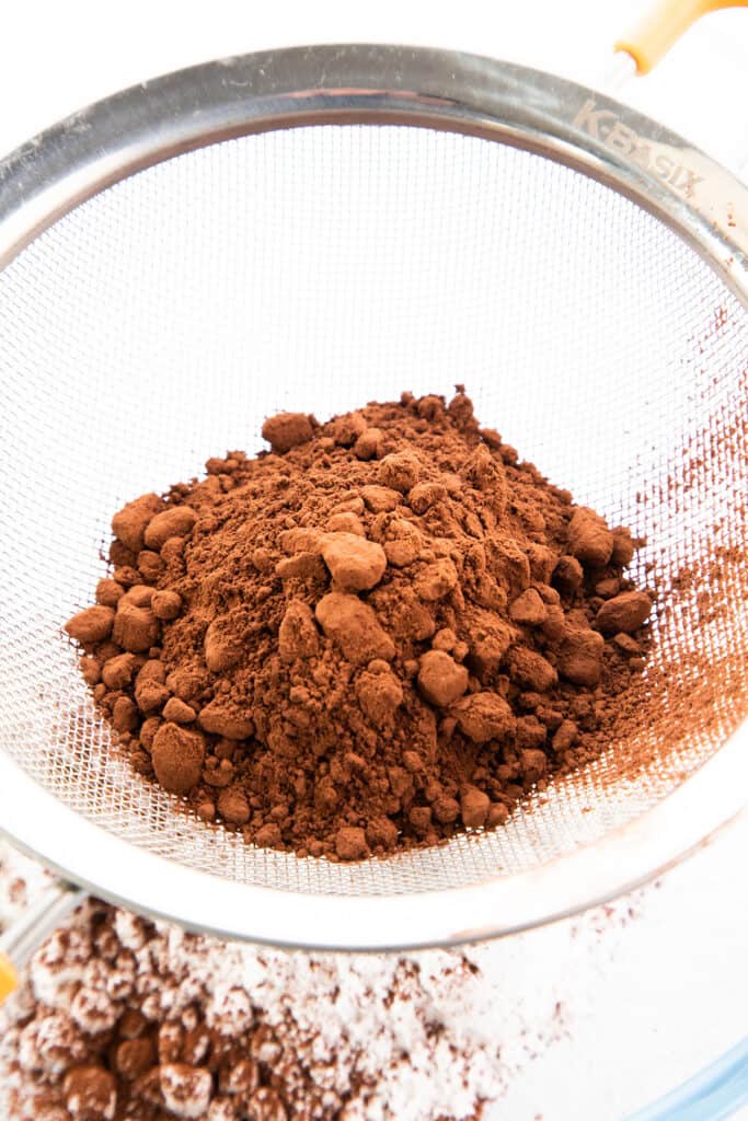 cocoa powder being sifted into a bowl