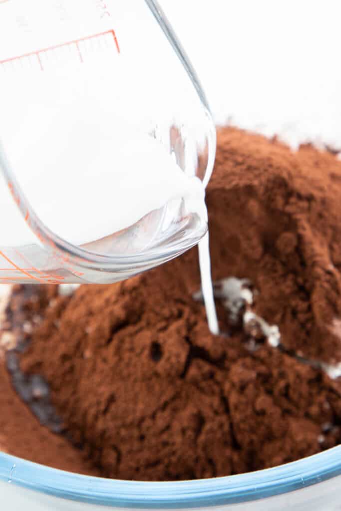 milk being poured into the cocoa powder mixture