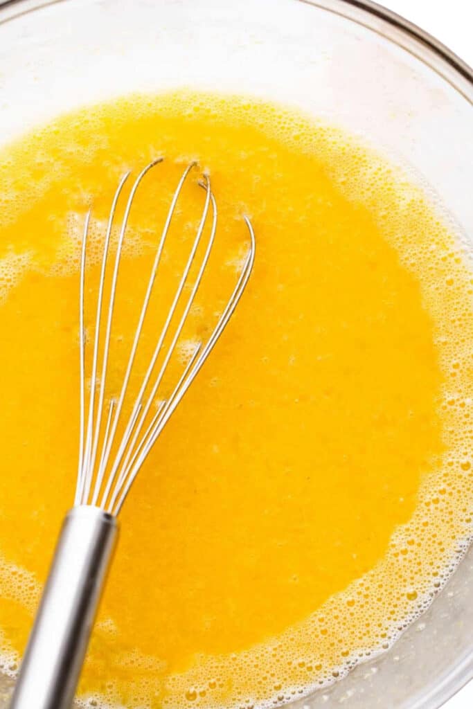a whisk in a bowl of lemon filling