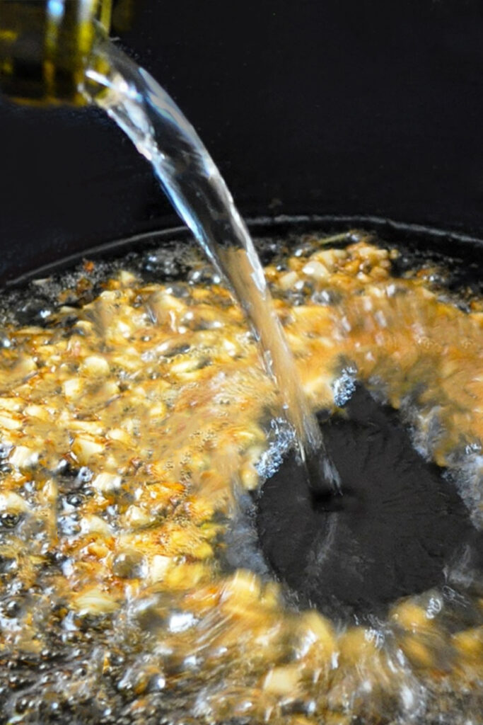 white wine being poured into a pan