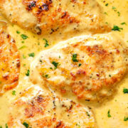 chicken breasts cooking in a mustard sauce