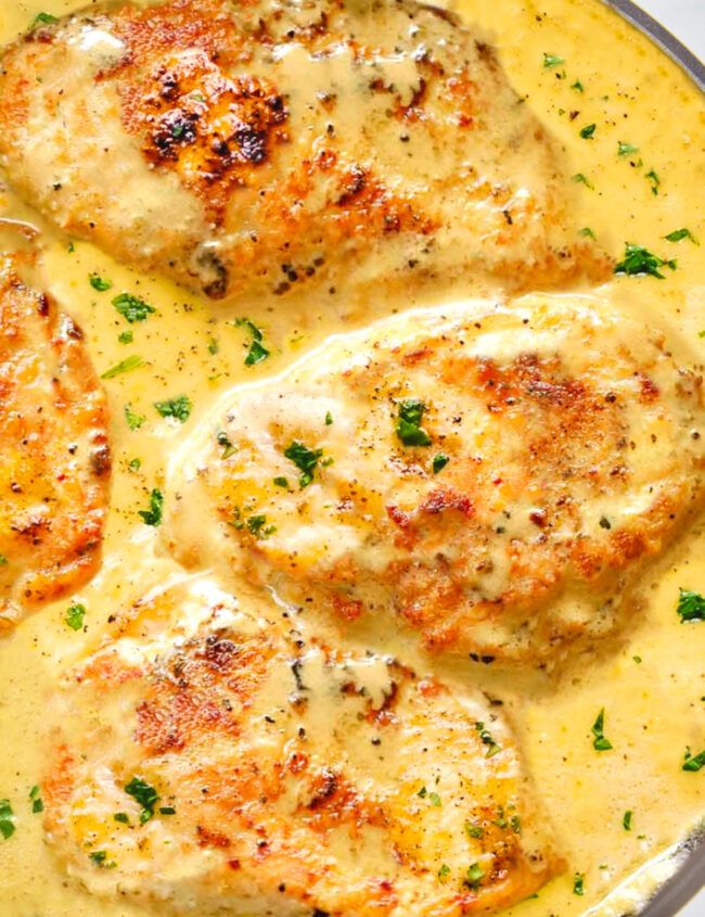 chicken breasts cooking in a mustard sauce