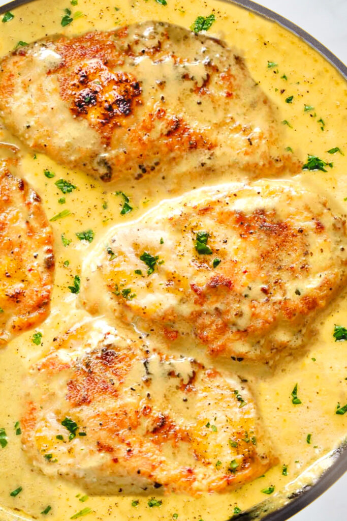 chicken breasts cooking in a mustard sauce