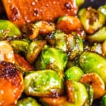 a close up image of Brussel sprouts in a pan covered in a brown sauce.
