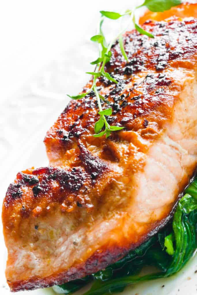 a crispy pan seared salmon fillet on a bed of spinach