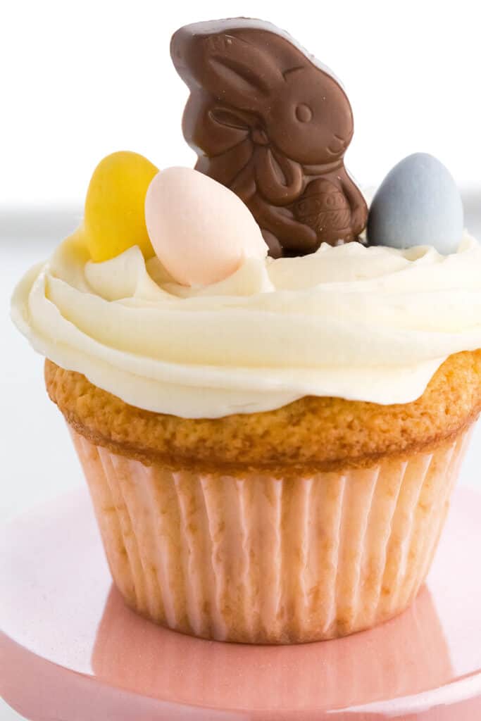 a cupcake with white frosting and easter candy on top
