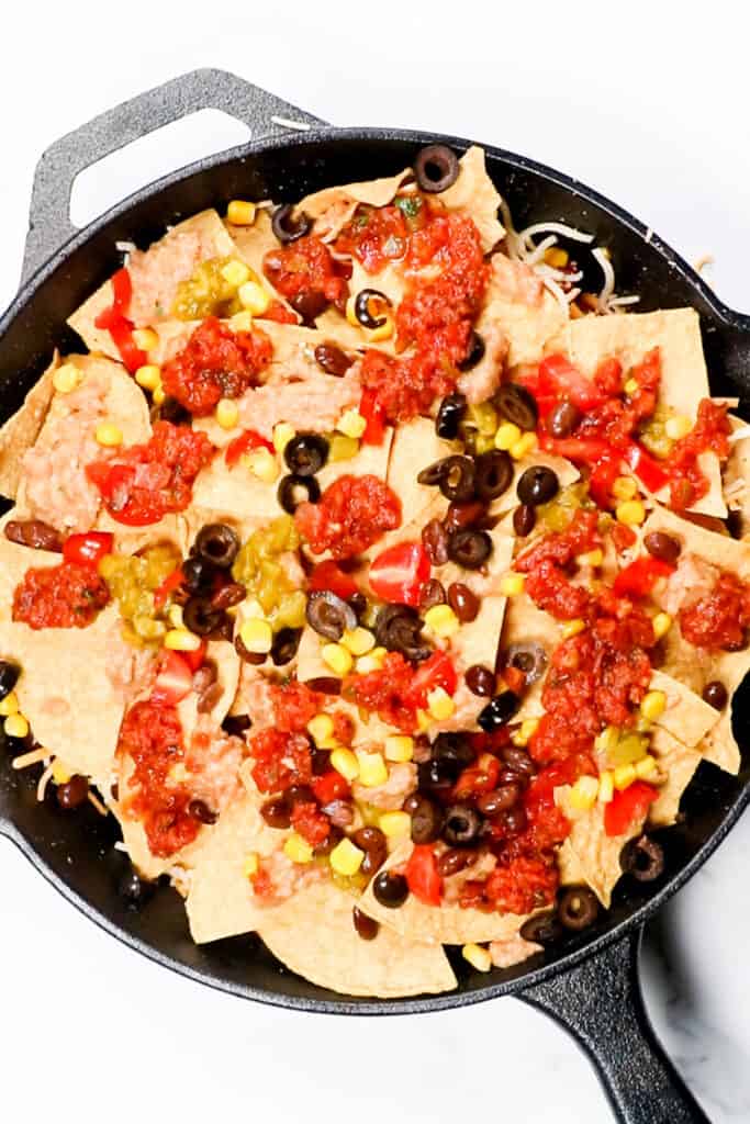 the third layer of nachos with toppings and salsa