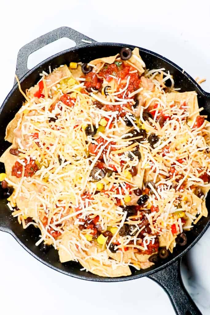 the third layer of the nachos topped with cheese