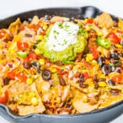 Hot nachos fresh from the oven topped with guacamole and sour cream.