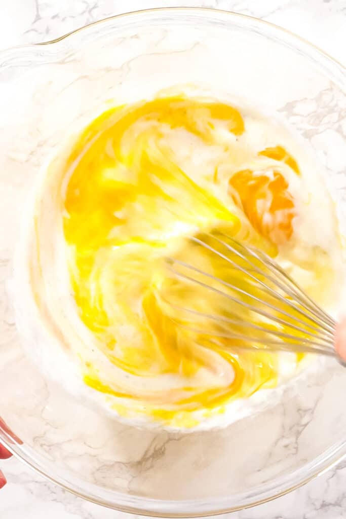 Mixing ingredients in a glass mixing bowl for spinach and mushroom frittata.
