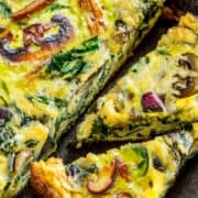 Spinach Mushroom Frittata in a pan sliced into wedges