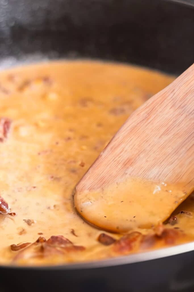 the creamy sauce for the Chicken Sundried Tomato Pasta cooking in a pan.