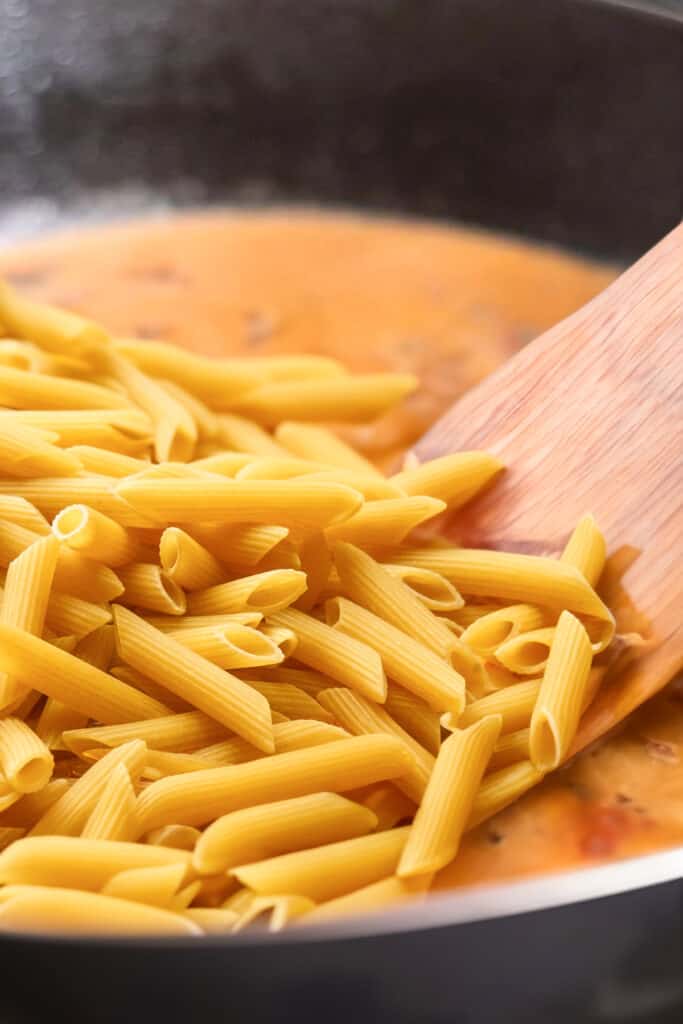 the pasta added to the pan with the sauce.